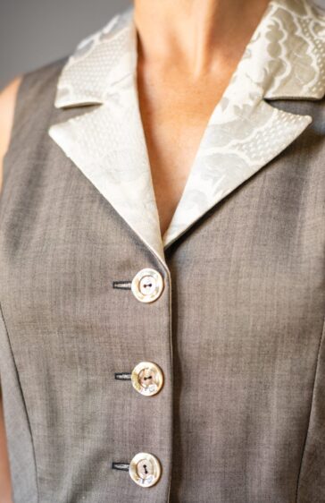 Détail d'un gilet en laine froide brune et col tailleur en brocard ivoire