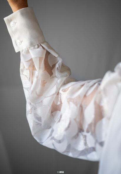 Détail d'une manche de chemisier en tulle dévoré blanc